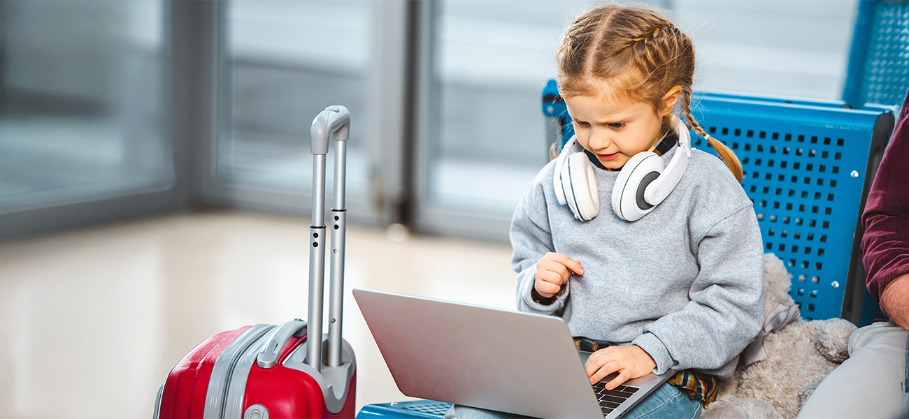 Image: Student using a laptop at a busy airport.