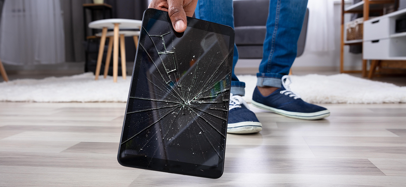 Man picking up damaged device from the floor.