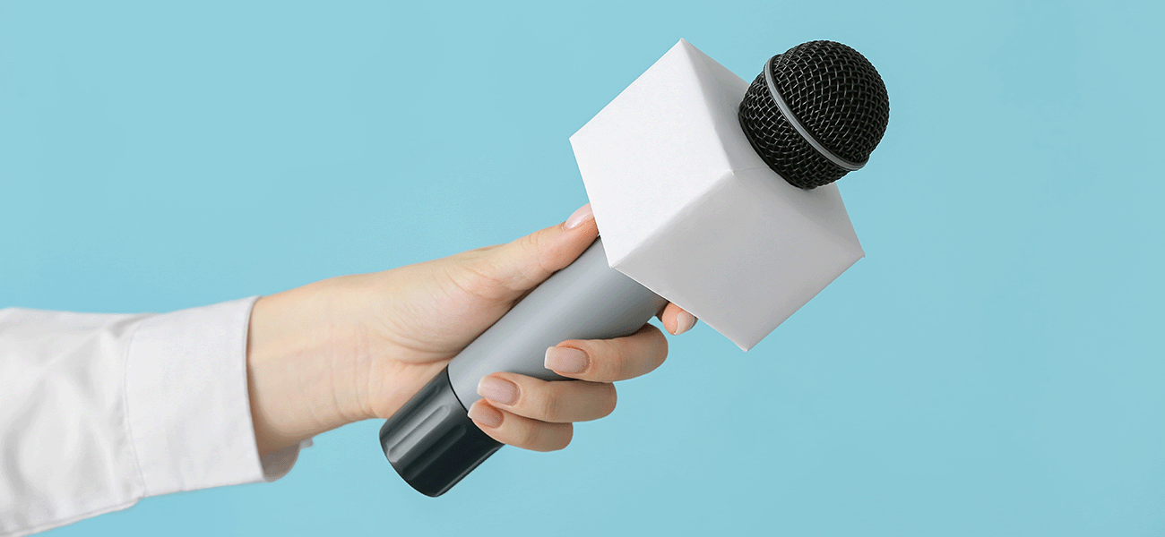 A hand holding up a microphone.