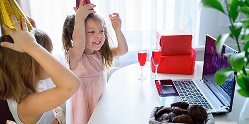 Image: Students at home celebrating a holiday on Zoom surrounded by drinks and snacks.
