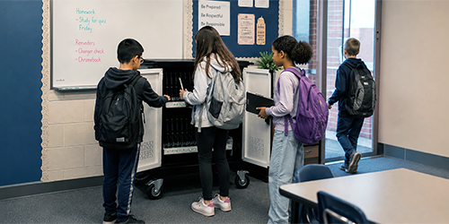 Image: Students grabbing chromebooks from a charging cart before leaving for the day.