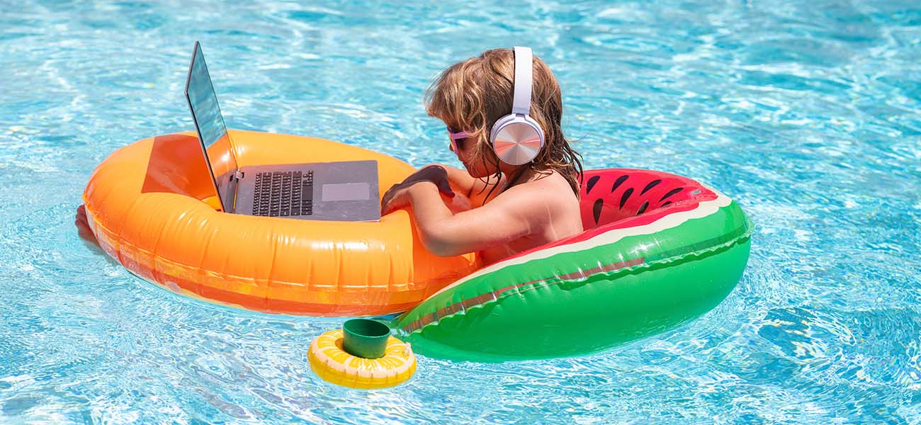 Kid in Pool With Laptop and Headphones