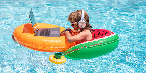 Kid in Pool With Laptop and Headphones