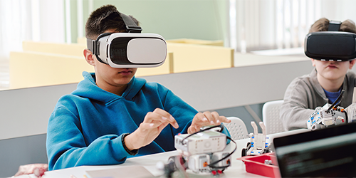 Image: Students in a classroom using augmented reality glasses to work on a project.